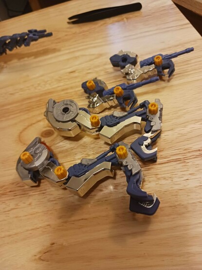 A photograph of all four of Abigail's limbs laid out in a line. The missile hatches on the hips and shoulders now have very shiny lids, and the arms have some gorgeous chromed silver armour on the underside of the forearm and the elbows. Meanwhile the legs have had several parts switched out, with grey hip parts and chromed silver thighs, front shin armour, and large toes. 