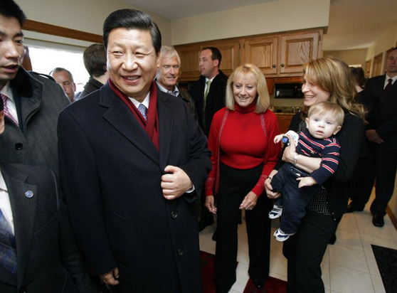 Xi Jinping laughs with an American family in an Iowa home. A baby looks confused as to what the situation is. 
