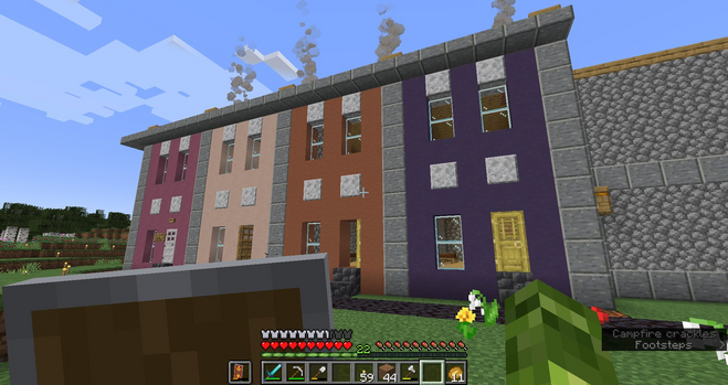 4 Rowhouses in Minecraft, each 2 story with similar construction, but with 4 different colors, magenta, peach, burnt orange, and dark purple. 
