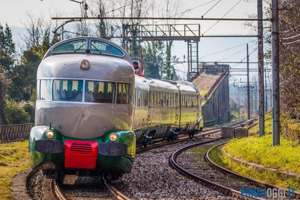 2 photos of the Arlecchino showing its unusual humpbacked appearance with the driver's cab so passengers can directly view straight out the front or back of the train as its moving. The grey and green streamlined trains but filled with strange colored bumps, look very much like the peak of 1960s technology and style. 